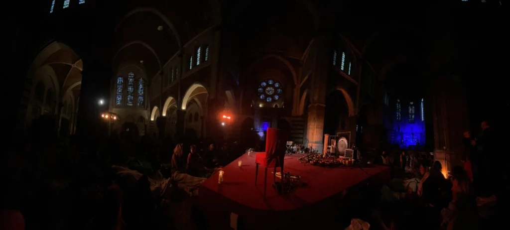 Setup de LEVITATION 360 ° dans l'église Sainte-Julienne : on voit le podium, des bougies et le gongs et autres bols tibétains